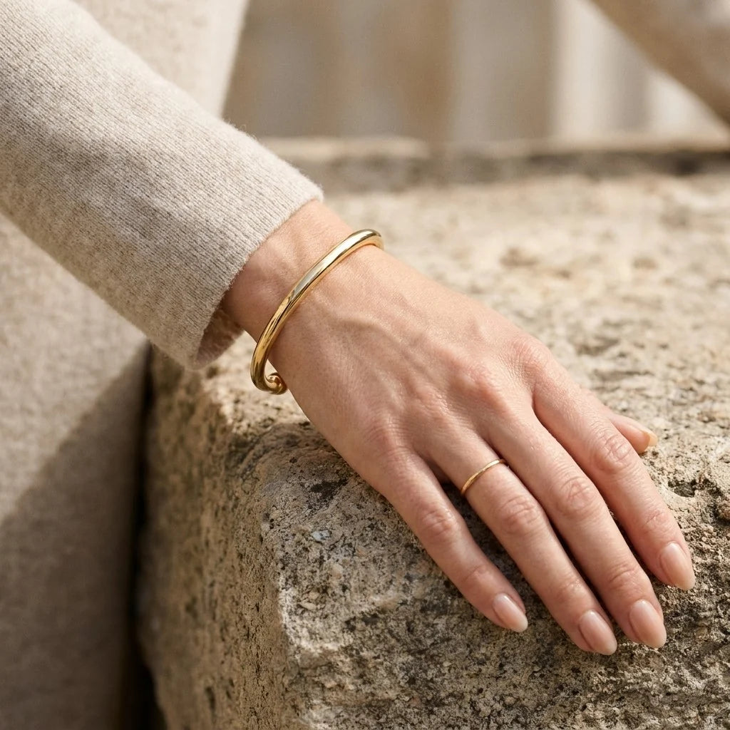 MAYA 01 Cap Ferrat gold cuff worn with a cream knit