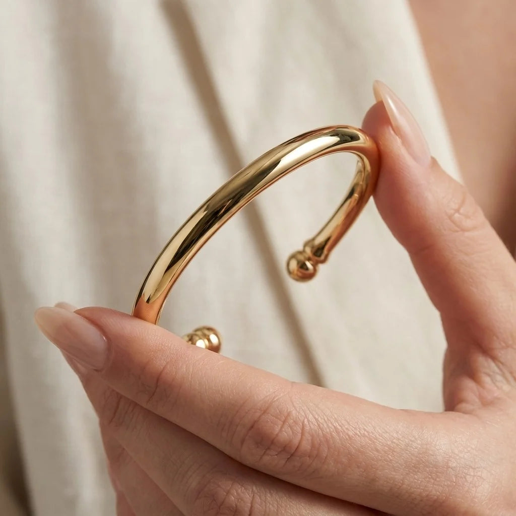 MAYA 01 Cap Ferrat gold cuff held in hand