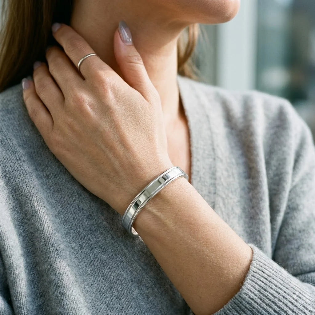 MAYA 01 Marbella polished silver cuff worn with a grey knit