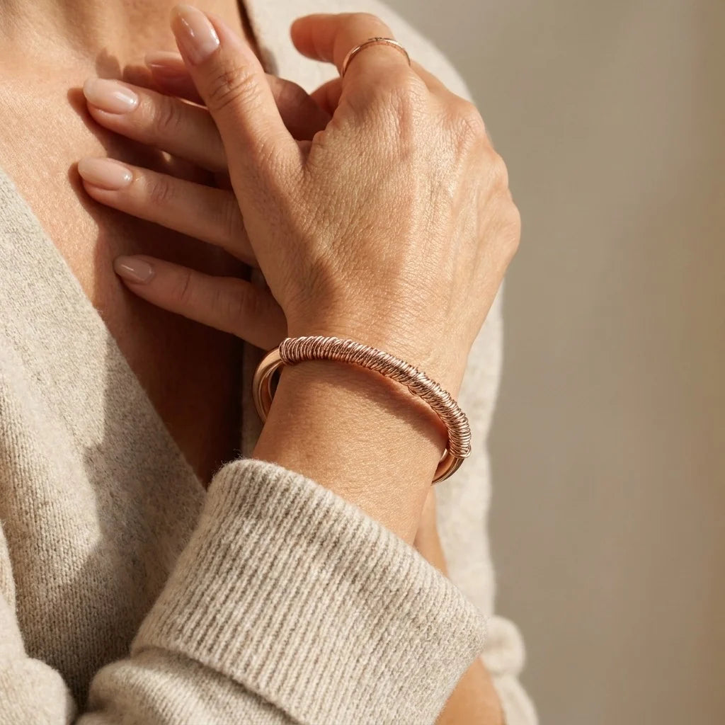 MAYA 01 Menton coiled cuff in Rose Gold worn with a soft cream knit and a rose gold ring