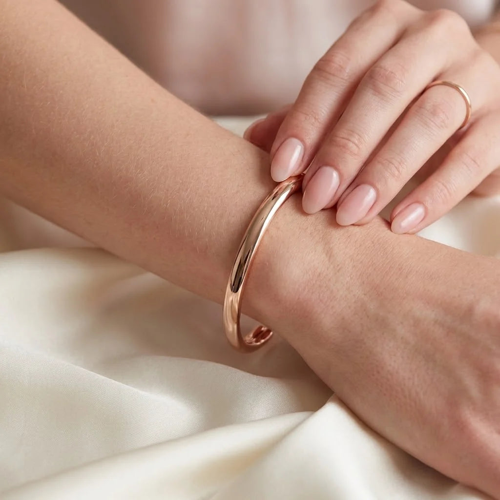 MAYA 01 Taormina cuff in Rose Gold worn on the wrist over ivory satin